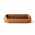 Barkkey Drago sculptural geometric pet bed with a faceted wooden frame and a plush brown tufted cushion.